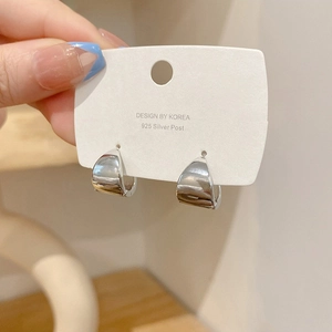 Close-up of chunky silver s925 hoop earrings on a Korean design display card