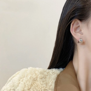 Elegant s925 silver C-shape hoop earrings worn by a model in a minimalist style