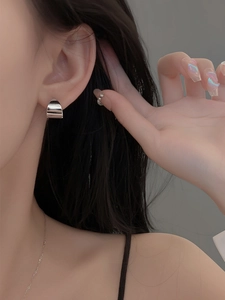 Minimalist polished silver ear cuff and matching stud shown on a model's ear