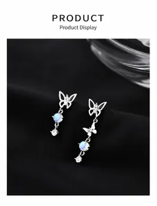Macro shot of silver asymmetrical butterfly earrings with moonstone and cubic zirconia