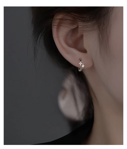 Detailed view of S925 silver starburst earrings with white zircon on ear lobe