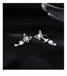 Macro detail of S925 silver asymmetric butterfly earrings with moonstone and zircon stones