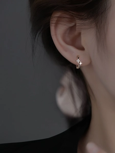 Macro detail of S925 sterling silver star hoop earring with pavé zircon stones on model