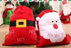 Dettaglio di sacchetti regalo in velluto natalizio con cintura di Babbo Natale e ricamo