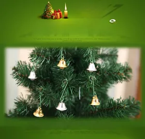 Close-up of gold and silver Christmas bells with green hooks on a festive tree branch