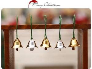 Close-up of gold and silver Christmas bells with green S-hooks for tree decoration