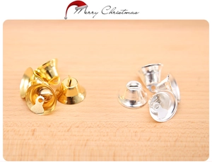 Close-up of shiny gold and silver Christmas bells with top holes for DIY crafts