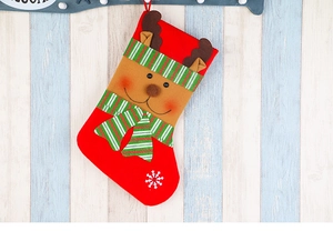 Detail of red felt Christmas stocking with 3D reindeer and white snowflake embroidery
