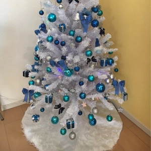White faux fur Christmas tree skirt with silver and blue ornaments for holiday decor