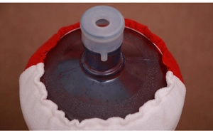 Close-up of red and white Christmas water dispenser cover with soft plush fabric details
