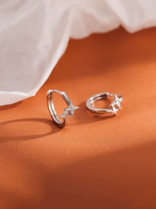 S925 sterling silver star hoop earrings with sparkling cubic zirconia on orange backdrop