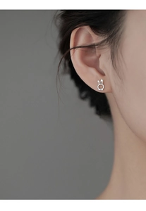 Close-up of S925 sterling silver rabbit stud earring with bow detail on a female ear