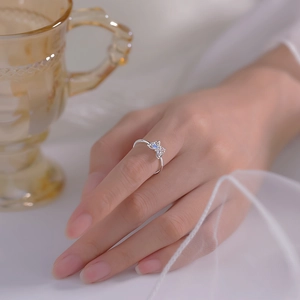 Detailed view of silver butterfly ring with pink and blue zircons on finger