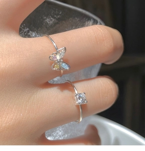 Detailed close-up of a delicate silver ring with a colorful zircon butterfly design