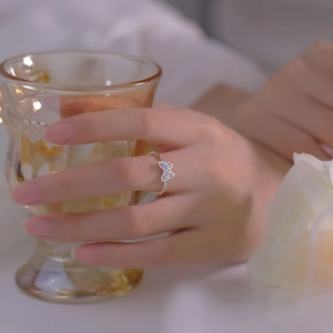 Close-up of a silver butterfly ring with colorful cubic zirconia on a model finger