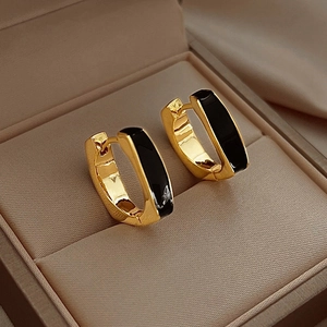Minimalist gold U-shaped hoop earrings with black enamel inlay on jewelry box