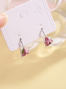 Detail of pink tulip earrings with silver hooks and delicate green leaf accents