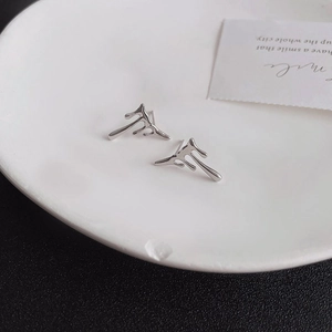 Macro shot of silver S925 lava drop earrings on a white minimalist display tray