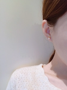 Cute bunny pearl stud earrings in gold finish worn by model on a soft background