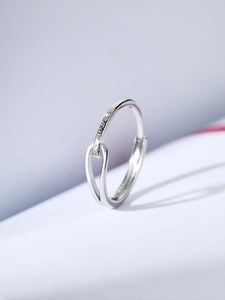 Macro view of S925 silver huggie earrings with frosted texture and wishbone design