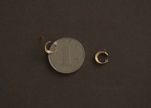 Boucles d'oreilles lune en argent S925 doré avec zircon à côté d'une pièce de monnaie