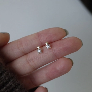 Vue macro des boucles d'oreilles étoiles en argent S925 et zircon sur les doigts