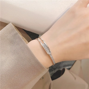 S925 silver open bangle with a pavé zircon oval frame shown on a woman wrist