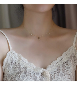 Detailed view of a gold S925 silver necklace with heart, cross, and star charms on neck