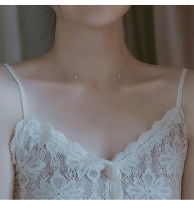 Detail of S925 silver necklace with cross, heart and star pendants on woman's neck