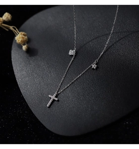 Detail of S925 silver necklace with sparkling heart, cross, and star pavé pendants