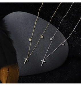Close-up of gold and silver S925 cross necklaces with sparkling star and heart charms