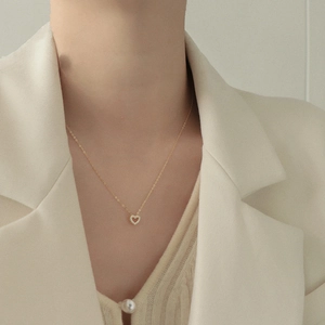 Detailansicht der goldenen hohlen Herz-Halskette mit funkelnden Kristallen an einem Model