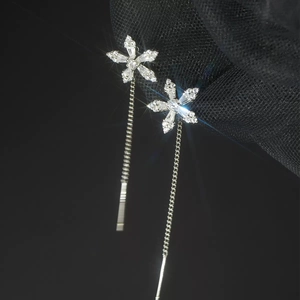 Macro detail of S925 silver snowflake earrings with cubic zirconia and long tassels