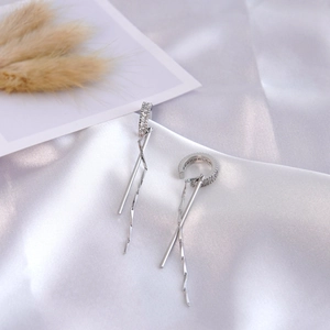 Silberne Quasten-Ohrclips mit Zirkonia-Details auf elegantem Seidenhintergrund