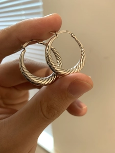 Close-up of S925 sterling silver hoop earrings with spiral twist texture and 925 hallmark