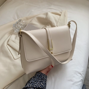 Elegant off-white faux leather crossbody bag with gold buckle and adjustable strap