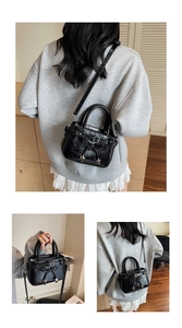 Détail du sac à bandoulière noir plissé avec cordon nœud et breloques étoile argent