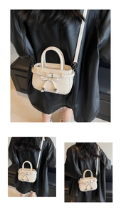 Détail d'un sac à nœud blanc crème avec texture cuir et pendentifs étoiles