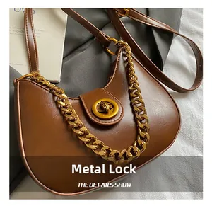 Dettaglio della borsa vintage marrone con chiusura in metallo dorato e tracolla a catena