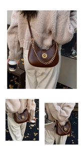 Detail van vintage bruine hobo tas met gouden ketting en draaisluiting in herfstsfeer