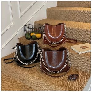 Chic bucket bags in black, tan and dark brown with chunky silver chain detail on stairs
