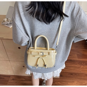Vue détaillée du sac bandoulière beige plissé avec nœud et étoiles sur un mannequin