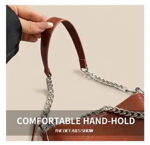 Detail of a brown leather handbag featuring a silver thick metal chain and handle