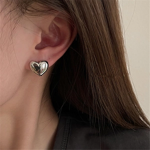 Elegant 3D heart-shaped silver stud earring with mirror finish shown on a female model