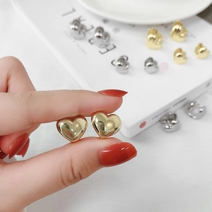 Minimalist polished 3D heart-shaped metal stud earrings in gold and silver finish