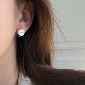 Close-up of minimalist S925 silver round earrings with a brushed matte metal finish