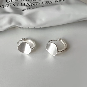 Detail of S925 sterling silver earrings with a modern matte brushed circular texture