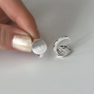 Minimalist brushed silver round hoop earrings with matte finish and secure clasp closure