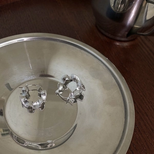 Macro detail of S925 sterling silver hoop earrings with vintage wavy pleated texture