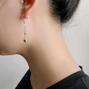 Gros plan de boucles d'oreilles cœur à pampilles en argent S925 montrant le mouvement